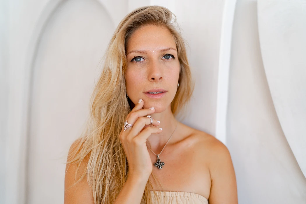 A blonde haired woman touching her chin checking for facial hair